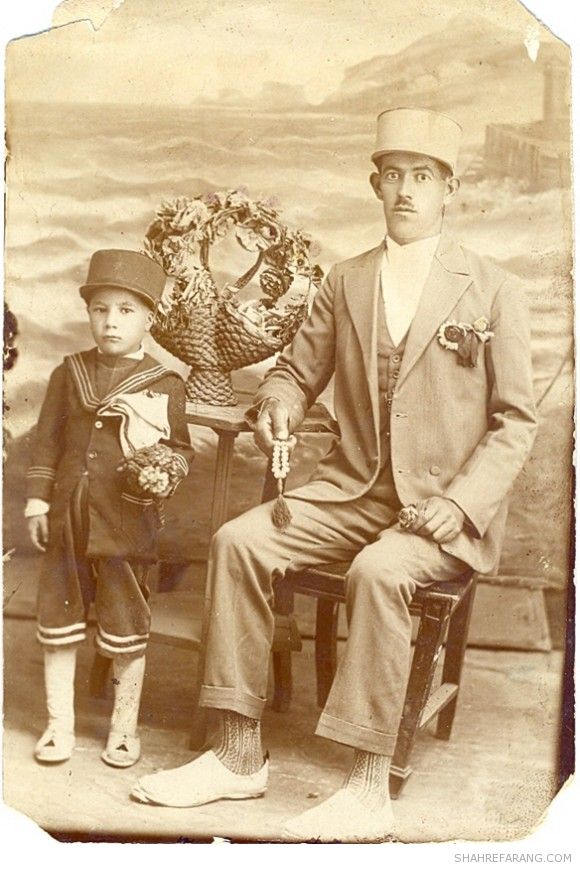 پدر و پسر با کلاه پهلوی، لباس جدید، و جوراب سنتی و گیوه، احتمالا ١٣٠۶ شمسی (۱۹۲۷ میلادی)